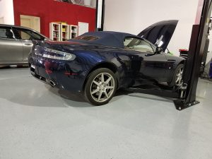 An Aston Martin with the hood open while it's being serviced at Active Euroworks